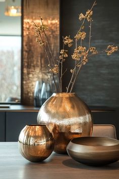 a vase with some flowers in it sitting on a table next to two bowls and plates