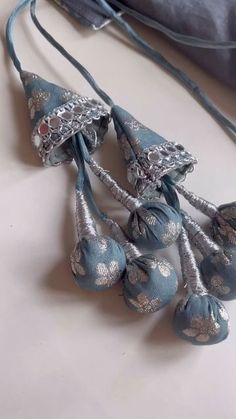 a group of blue and silver bells hanging from a string on a table next to a bag