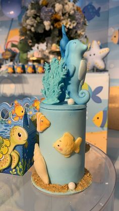 there is a blue cake with sea animals on it and other decorations around the cake