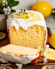 a loaf of lemon pound cake with white icing and sliced lemons on the side