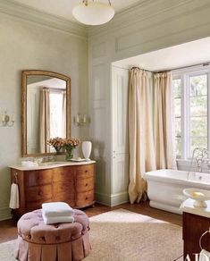 a bath room with a tub a sink and a mirror on the wall next to a window