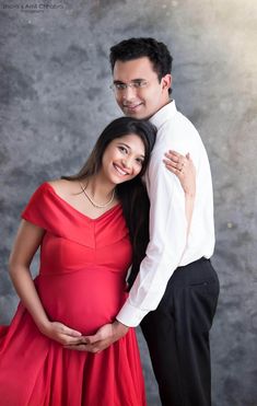 a pregnant woman and man pose for a photo