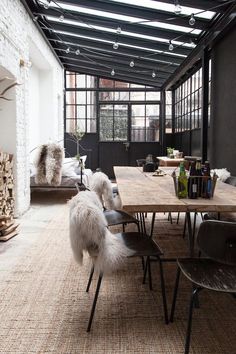 a dining room table with chairs and a bench in front of an open fire place