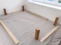 two wooden posts laying on top of a sheet covered floor