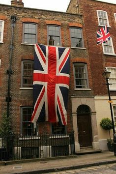 a large union jack flag hanging from the side of a building