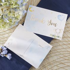 two thank you cards sitting on top of a table next to hydrangeas and flowers