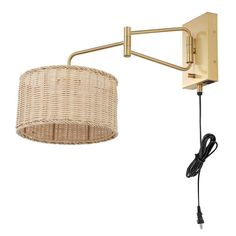 a wall light with a wicker shade hanging from it's arm and plugged in