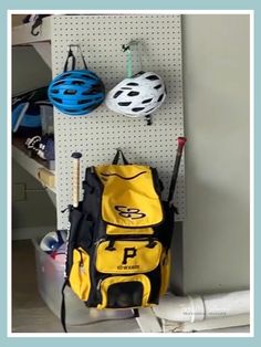 there is a yellow backpack hanging on the wall next to a blue and white bag