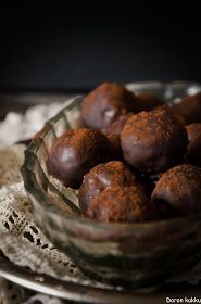 a glass bowl filled with chocolate truffles on top of a lace doily