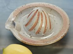 a lemon sitting next to a ceramic bowl