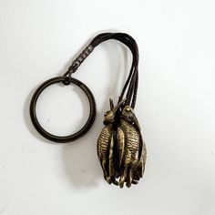 a keychain with two birds hanging from it's side on a white surface