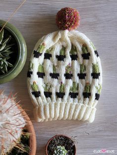 a knitted hat sitting on top of a wooden table next to potted plants