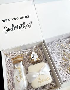 an open box with a bottle and some items in it that say, will you be my godmother?