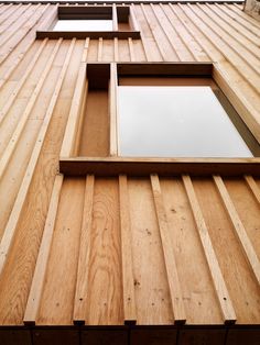 the side of a wooden building with two windows