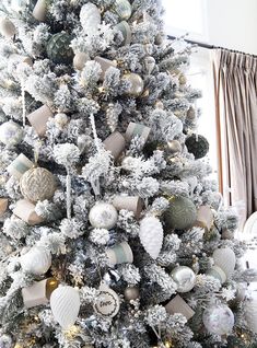 a white christmas tree with silver and gold ornaments