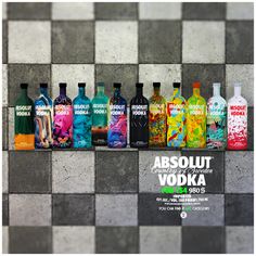 an advertisement for absolut vodka on a tiled wall with bottles lined up in rows