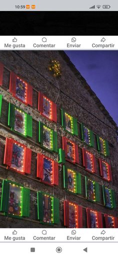 an image of christmas lights on the side of a building with green and red shutters