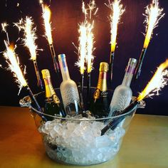 there are many champagne bottles in the ice bucket with sparklers on it and some bubbles