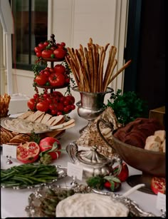 a table topped with lots of different types of food on top of a white table cloth