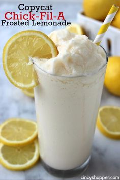 a close up of a drink in a glass with lemons around it and the words copycat chick - fil - a frosted lemonade