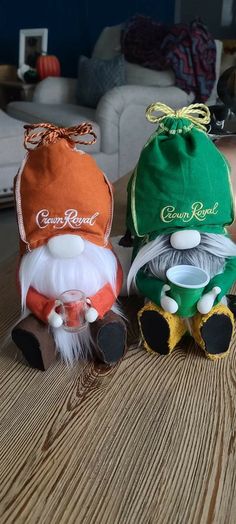 three little gnomes sitting on top of a wooden table next to each other and one is wearing a green hat