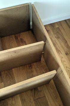 an unfinished wooden bench sitting on top of a hard wood floor