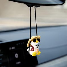 a stuffed animal hanging from the dashboard of a car