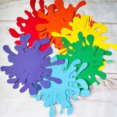 four different colored handprints on a white surface, one is multicolored