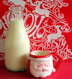 a bottle of milk next to a cup with a santa clause on it