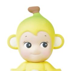 a yellow monkey toy sitting on top of a white surface