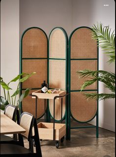 the room dividers are made out of bamboo and green caned screens, with two chairs