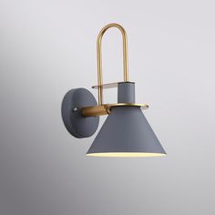 a gray and gold wall light on a grey wall with a white backround