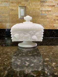 a white vase sitting on top of a counter