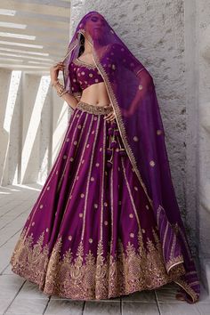 Midnight purple lehenga with gold dori and aari embroidered floral motifs. Paired with blouse and dupatta.
Components:3
Pattern:Embroidery
Type of Work:Dori, aari, floral
Neckline:V neck
Sleeve Length:Half
Fabric:Chiniya silk, organza
Color:Purple
Other Details:
Side tassel tie-up
Embroidered sheer dupatta
Note: Hair accessory worn by the model is not for sale
Occasion:Bride - Aza Fashions Purple And Gold Lehenga, Purple Chanderi Traditional Wear With Dori Work, Purple Sharara With Dori Work For Diwali, Purple Dori Work Sharara For Diwali, Festive Purple Dupatta With Dori Work, Diwali Purple Sets With Gota Work, Purple Diwali Sets With Gota Work, Diwali Purple Gota Work Sets, Purple Chanderi Traditional Wear With Meenakari