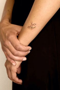 a woman's arm with a small tattoo on it