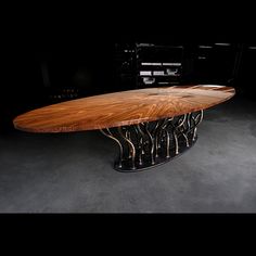 a large wooden table sitting on top of a gray floor next to a black wall