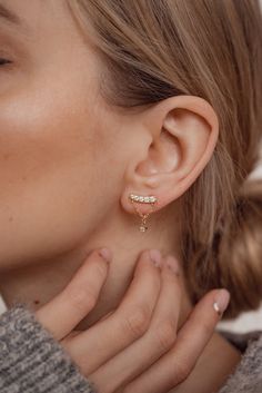 These are 18 karat gold-plated sterling silver stud earrings which have a gently arched metal rod decorated with five tiny round zirconia (which sits on the ear lobe), and a single round zirconia in a four-prong setting hanging underneath it, attached by a delicate golden chain in the shape of a triangle. Golden butterfly clasps secure them to the ear. A unique and glamorous design that will be sure to elevate any look. 🎁 Packaging: Beautifully packed in a box, ready for gifting. 🏷️ This produ Gold Cubic Zirconia Ear Climbers Fine Jewelry, Gold Cubic Zirconia Ear Climbers With Prong Setting, Classic Gold Diamond Ear Climbers, Gold Diamond Ear Climbers For Gifts, Formal Gold Cubic Zirconia Ear Climbers, Diamond Gold Ear Climbers As Gift, Gold Cubic Zirconia Ear Climbers For Formal Occasions, Gold Cubic Zirconia Ear Climbers For Formal Events, Minimalist Gold Diamond Ear Climbers