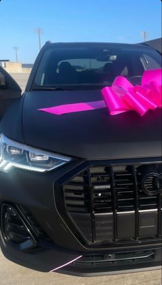 a car with a pink bow on the hood