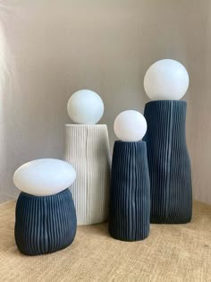 three white and blue vases sitting on top of a table