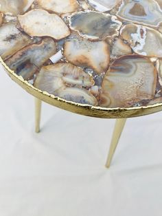 a table that has been made out of agate and gold leafy designs on it