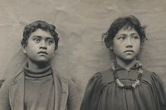 an old photo of two children with their heads turned to look like they are looking at something