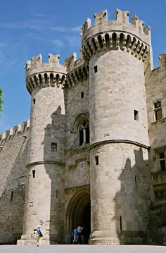 two people are standing in front of an old castle