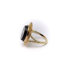 This is part of Chairish’s Fine Jewelry assortment.  This is a beautiful 14k gold ring that is part of our Signature Collection. There is a 14k split shank that has been attached to a Victorian era micro mosaic bird set in a tablet of onyx and surrounded by a hand engraved 14k gold border. The onyx tablet measures 13mm by 15mm and the ring is a size 5 1/2.  The bird is made using a painstaking technique that involves creating an image out of small pieces of opaque enamel glass called tesserae. T Cameo 14k Gold Round Jewelry, 14k Gold Cameo Round Jewelry, 14k Gold Cameo Jewelry, Victorian Memorial Jewelry Ring, 14k Gold Cameo Signet Ring Gift, Fine Jewelry: 14k Gold With Intaglio Detail, Fine Jewelry 14k Gold With Intaglio, Fine 14k Gold Jewelry With Intaglio, 14k Gold Round Intaglio Jewelry