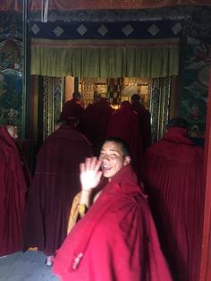 a group of people in red robes standing next to each other with their hands up