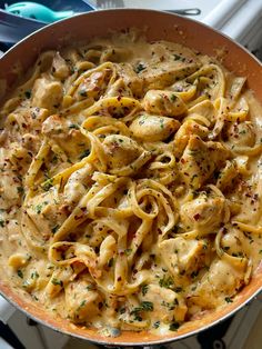 a skillet filled with pasta and chicken