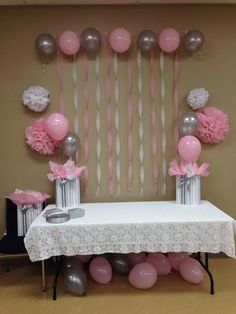 pink and silver baby shower decorations on a table