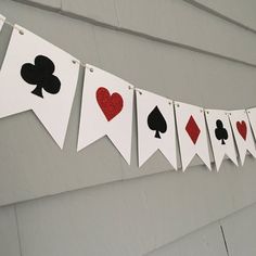 playing cards are hung on a string with hearts and spades