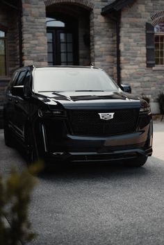 a black car parked in front of a house