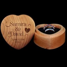 a wooden ring box with an engraved heart on the front and inside, sitting next to a black background