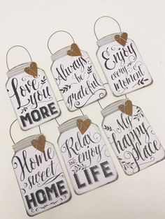 six mason jars with sayings hanging from the top, each one has a heart on it